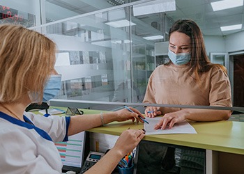 Patient in Melbourne filling out paperwork for root canal financing